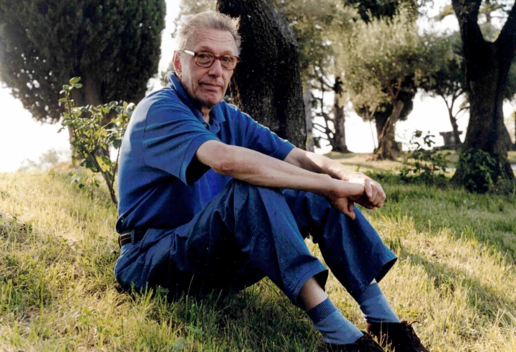 Gilberto Barburini seduto sull'erba di una radura in compagnia